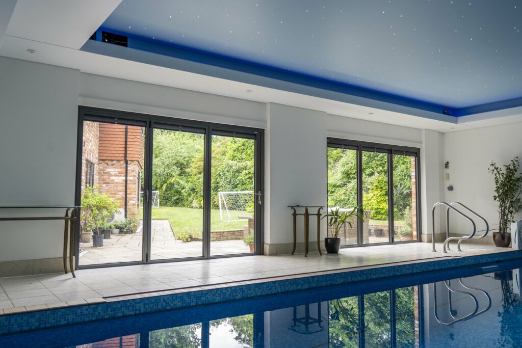 Dark Grey Metallic Bifold Doors with Blinds for a Luxurious Indoor Swimming Pool, Windsor