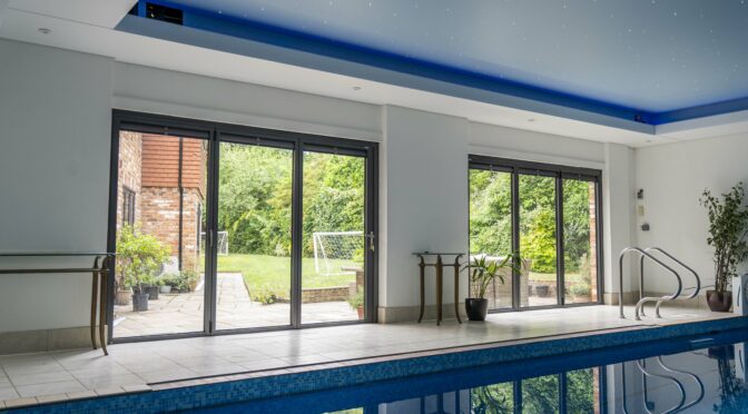 Dark Grey Metallic Bifold Doors with Blinds for a Luxurious Indoor Swimming Pool, Windsor